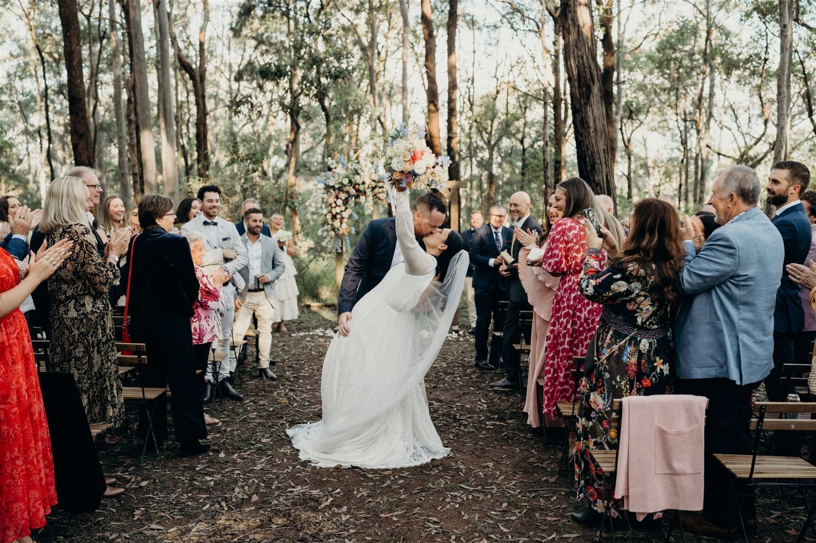 A bride walking the gravel aisle through standing guests