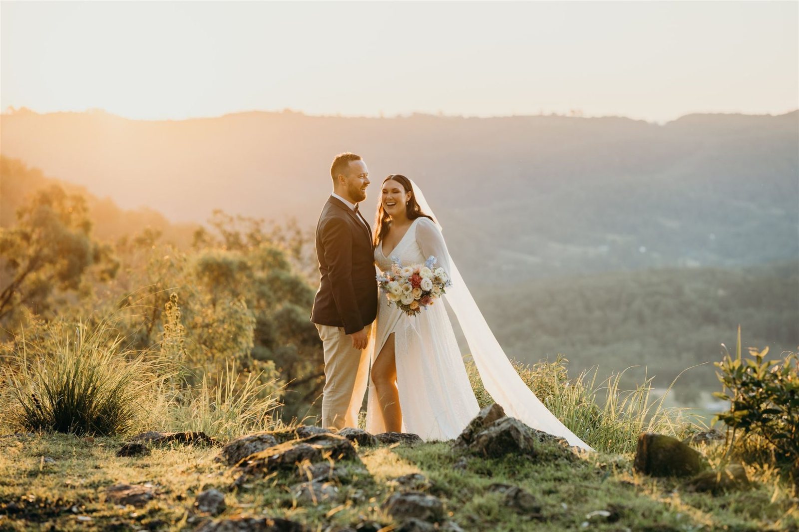 A couple at the clifftop lookout as the sun sets over the ranges
