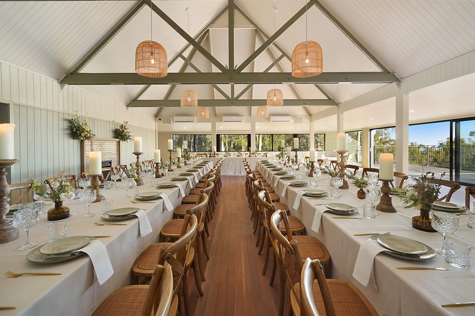 The reception room with its white vaulted ceiling, exposed trusses and long timber tables